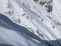 an aerial view of a person on skis jumping off a cliff into the snow