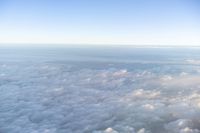 view of the sky from inside of an airplane with some clouds in the sky and in the water below