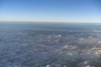 view of the sky from inside of an airplane with some clouds in the sky and in the water below