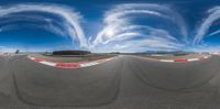 360 - 360 lens photography of a curve near an airport with clouds in the sky