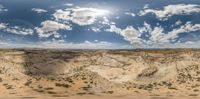 a panoramic view of a landscape and sky showing the terrain of the desert