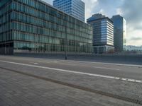 the road is empty on this busy street with the tall building in the background for pedestrians