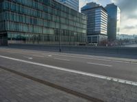 the road is empty on this busy street with the tall building in the background for pedestrians