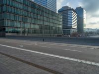 the road is empty on this busy street with the tall building in the background for pedestrians