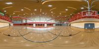 a sports court has two rows of wooden floors and light fixtures on the ceiling above