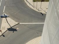 an overhead view of the street intersection with some cars driving along it's curb