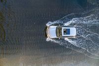 a boat in the water next to another car in the ocean in mid air view