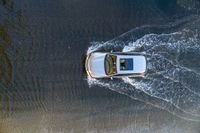 a boat in the water next to another car in the ocean in mid air view