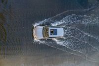 a boat in the water next to another car in the ocean in mid air view