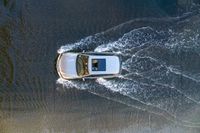 a boat in the water next to another car in the ocean in mid air view