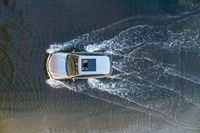 a boat in the water next to another car in the ocean in mid air view