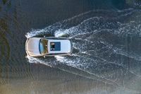 a boat in the water next to another car in the ocean in mid air view