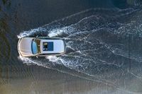 a boat in the water next to another car in the ocean in mid air view