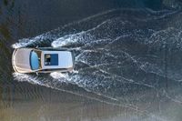 a boat in the water next to another car in the ocean in mid air view