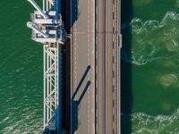 this is an overhead view of the river and bridge that connects to the bridge, where cars are traveling