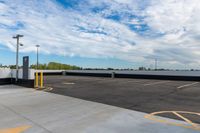 a parking lot filled with lots of parking space next to a building and the blue sky