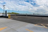 a parking lot filled with lots of parking space next to a building and the blue sky