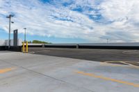 a parking lot filled with lots of parking space next to a building and the blue sky