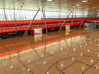 inside a gym with a wooden floor and multiple tall windows that provide light and ventilation