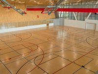 a gym has wood floors and is surrounded by wooden ceiling tiles, and red lines show where it intersects