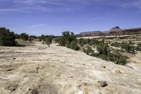 a scenic scene shows the valley with barren terrain in the background of red and green mountains