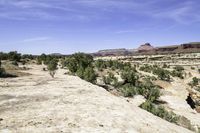 a scenic scene shows the valley with barren terrain in the background of red and green mountains