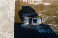 a car driving through the water in the ocean from above the side of a boat