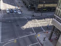 an aerial shot of two cars on a city street at a busy intersection in front of a large building