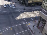 an aerial shot of two cars on a city street at a busy intersection in front of a large building