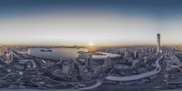 a fisheye lens view of city skylines with tall buildings and boats at dawn