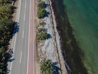 an aerial view of the highway leading to water and beach area, with a red line