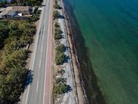 an aerial view of the highway leading to water and beach area, with a red line