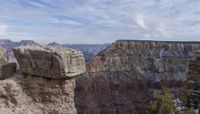 the rocks and trees are sticking out of the cliff formations over the canyon floor of the mountain