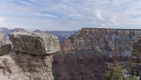 the rocks and trees are sticking out of the cliff formations over the canyon floor of the mountain