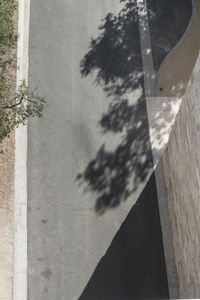 an aerial view of a couple walking across the street near a skateboard ramp at the beach