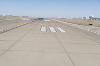 a large runway with no people on the ground in the background is a clear sky and several buildings