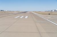 a large runway with no people on the ground in the background is a clear sky and several buildings