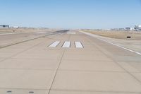 a large runway with no people on the ground in the background is a clear sky and several buildings