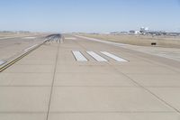 a large runway with no people on the ground in the background is a clear sky and several buildings