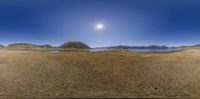 a photo taken in a 3d camera of desert terrain, and the sun over the mountains