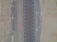 an airplane traveling over a deserted highway with a sign on it that reads i - 70