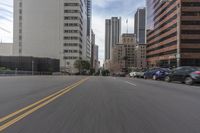 a city street is lined with tall buildings and buildings, and cars are driving on it