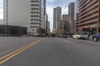 a city street is lined with tall buildings and buildings, and cars are driving on it