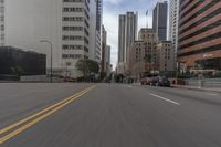 a city street is lined with tall buildings and buildings, and cars are driving on it