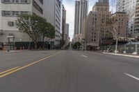 a city street is lined with tall buildings and buildings, and cars are driving on it