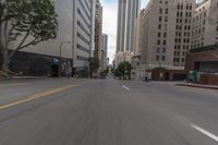 a city street is lined with tall buildings and buildings, and cars are driving on it