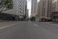 a city street is lined with tall buildings and buildings, and cars are driving on it