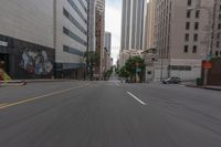 a city street is lined with tall buildings and buildings, and cars are driving on it