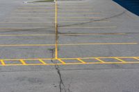 an empty parking lot with several lines painted on it in yellow and black colors as shown from above