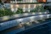 an empty ramp runs through the city as the road goes under it near a parking garage